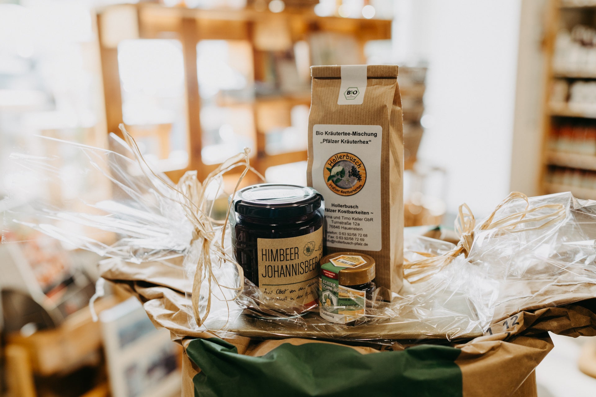 Geschenk „Naschkätzel“ von Hollerbusch – liebevoll verpacktes Feinkost-Geschenkset mit Himbeer-Johannisbeer-Gelee, Pfälzer Honig und Kräutertee für süße Genussmomente.